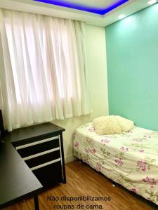a bedroom with a bed and a table and a window at Lazer completo com Vistas de um Belo Horizonte in Belo Horizonte