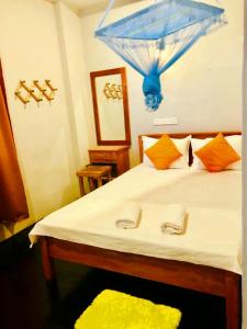 a bedroom with a bed with a blue umbrella on it at The Orange House Weligama in Matara