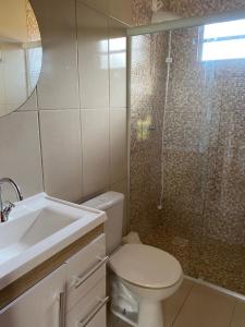 a bathroom with a shower and a toilet and a sink at CASA GAMBOA BEACH in Garopaba