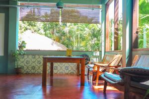 a room with a table and chairs and a window at Pipes Hostel in Kuta Lombok