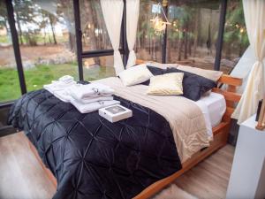 a bedroom with a large bed with a tray on it at El Prado Glamping in Susudel  