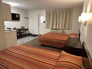 a hotel room with two beds and a table at Yellow Quill Motel in Portage La Prairie
