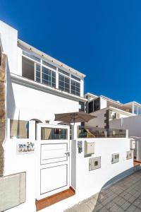 Biały dom z otwartymi drzwiami w obiekcie Luxury Beach Tanza w mieście Playa Honda