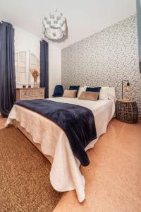 - une chambre avec un grand lit et une couverture bleue dans l'établissement Luxury Beach Tanza, à Playa Honda