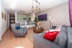 a living room with a couch and chairs and a kitchen at Luxury Beach Tanza in Playa Honda