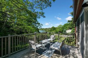 バー・ハーバーにある2 BR Home w/ Pondside View Backyard [Maine Escape]の家の上に椅子とテーブル付きのデッキ