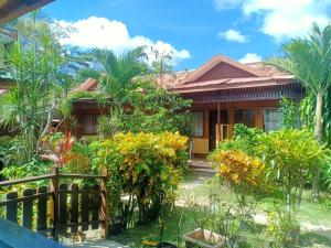 a house with a garden in front of it at Telesfora Beach Cottage in El Nido