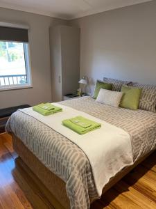 a bedroom with a large bed with two green towels on it at Sinclairs Country Retreat - Welcoming Guests 18 years and older in Conjola +50 photos
