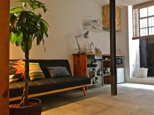 a living room with a black couch and a plant at Casa da Travessa in Lisbon