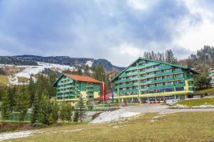 a large building in front of a mountain at Alpine Club Apartement für 6 Personen in Schladming