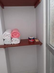 a shelf in a bathroom with towels on it at Hospedaje EL MARQUEZ Expat in Máncora