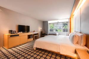 Habitación de hotel con cama y TV de pantalla plana. en Wulai Pause Landis Resort, en Wulai