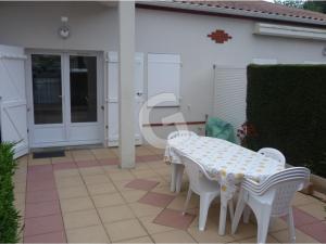 una mesa blanca y sillas en un patio en Appartement La Tranche-sur-Mer, 3 pièces, 4 personnes - FR-1-357-12, en La Tranche-sur-Mer