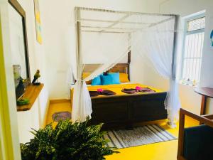 a bedroom with a bed with a canopy at Birdsong Villa Private Garden Retreat in Ratgama Hegoda