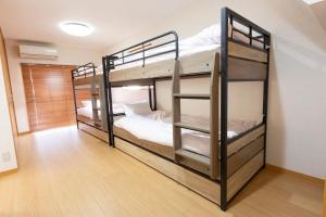 una habitación con dos literas en una habitación en アブラハウス別府, en Beppu