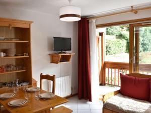 ein Esszimmer mit einem Tisch und einem TV in der Unterkunft Appartement Méribel, 2 pièces, 4 personnes - FR-1-180-378 in Les Allues