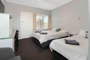 a hotel room with two beds and a window at The Tree Motel in Narooma