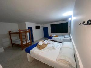 a hotel room with two beds and a chair at HOTEL BRISAS DE SANTA FE in Santa Fe de Antioquia