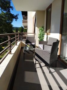 un patio con sedie e un tavolo su un balcone di CONDOMINIO LOS CASTAÑOS ALICURA, PUCÓN, departamento 2 dormitorios, 1 baño, estacionamiento, piscina a Pucón