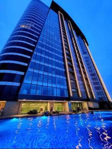 a tall blue building with a pool in front of it at Aeon Tower 2627 in Davao City