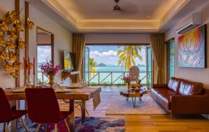 a living room with a table and a couch at Coconut Grove Resort in Ko Yao Yai