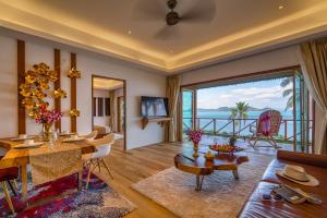 a living room with a view of the ocean at Coconut Grove Resort in Ko Yao Yai