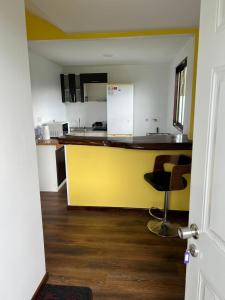 uma cozinha com um balcão amarelo num quarto em Cabañas Vista Volcanes I em Puerto Varas