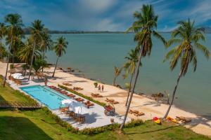 a view of a beach with a pool and palm trees at Coconut Grove Resort in Ko Yao Yai