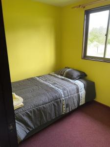 a bed in a room with a window at Cabañas Vista Volcanes I in Puerto Varas