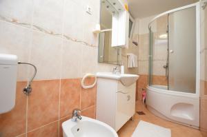 een badkamer met een toilet, een wastafel en een spiegel bij Apartment Gianfranko in Opatija