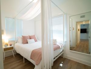 Habitación blanca con cama y espejo en Calming And Renovated Near Dt St Pete Pier 2 King, en San Petersburgo