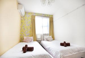 two twin beds in a room with a window at 優宿 Kitakoiwa in Tokyo