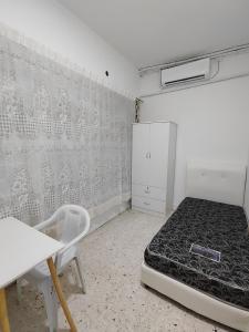 a bedroom with a bed and a table and a chair at GP Hostel Penang in George Town