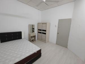 a white room with a bed and a closet at GP Hostel Penang in George Town