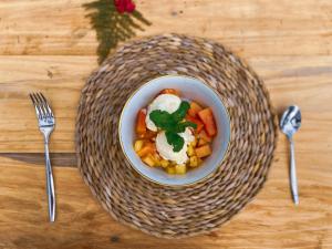 a bowl of food on a table with two forks at Eco Wild Glamping Bambarakanda 