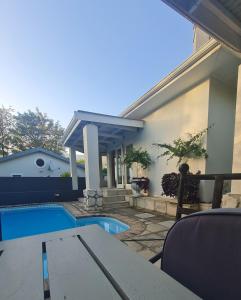 a patio with a table and a swimming pool at Bergview Guesthouse Swellendam in Swellendam