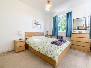 a bedroom with a bed with blue curtains and a mirror at Low Bank in Lancaster