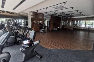 einen Fitnessraum mit Laufbändern und Kardiogeräten in einem Zimmer in der Unterkunft AYMAR Homestay, Residensi Lily, Nilai in Nilai