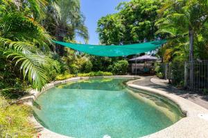 uma piscina no meio de um quintal com árvores em Tranquil 3BR King Home, Pool, BBQ em Trinity Beach