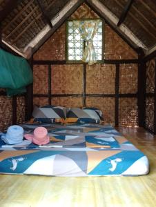 - une chambre avec un lit dans une pièce dotée d'une fenêtre dans l'établissement LHOYJEAN Garden Hostel, à Batuan