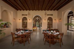 une salle à manger avec des tables et des chaises en bois dans l'établissement Time Square Resort & Spa Bhuj, à Bhuj