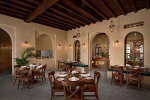 - un restaurant avec des tables et des chaises dans une salle dans l'établissement Time Square Resort & Spa Bhuj, à Bhuj