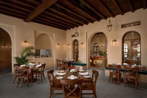 a restaurant with tables and chairs in a room at Time Square Club, Resort & Spa in Bhuj