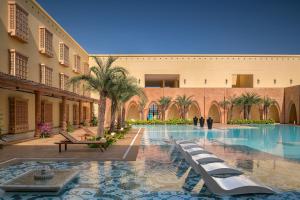 a swimming pool in a building with palm trees at Time Square Resort & Spa Bhuj in Bhuj