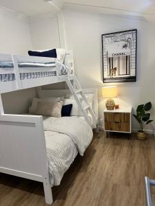 a bedroom with a white bunk bed and a desk at Comfortable Beach Home Scarborough in Scarborough