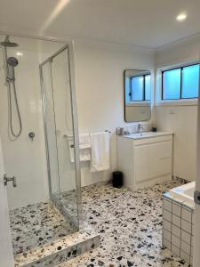 a bathroom with a shower and a sink at Comfortable Beach Home Scarborough in Scarborough