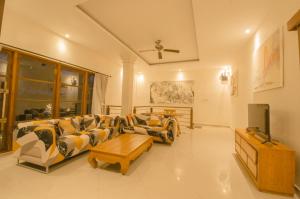 un soggiorno con divani e TV a schermo piatto di Luxury Villa Ada Padi Ubud ad Ubud
