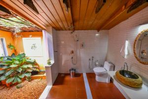 a bathroom with a sink and a toilet and a plant at Swasthi Serviced Villa in Kanjirapalli