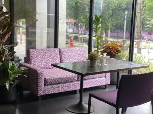 un tavolo e due sedie in una stanza con tavolo di Brighton Hotel a Bangkok