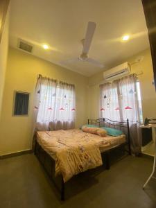 Bagan SeraiにあるMAMA homestayのベッドルーム1室(ベッド1台、窓2つ付)